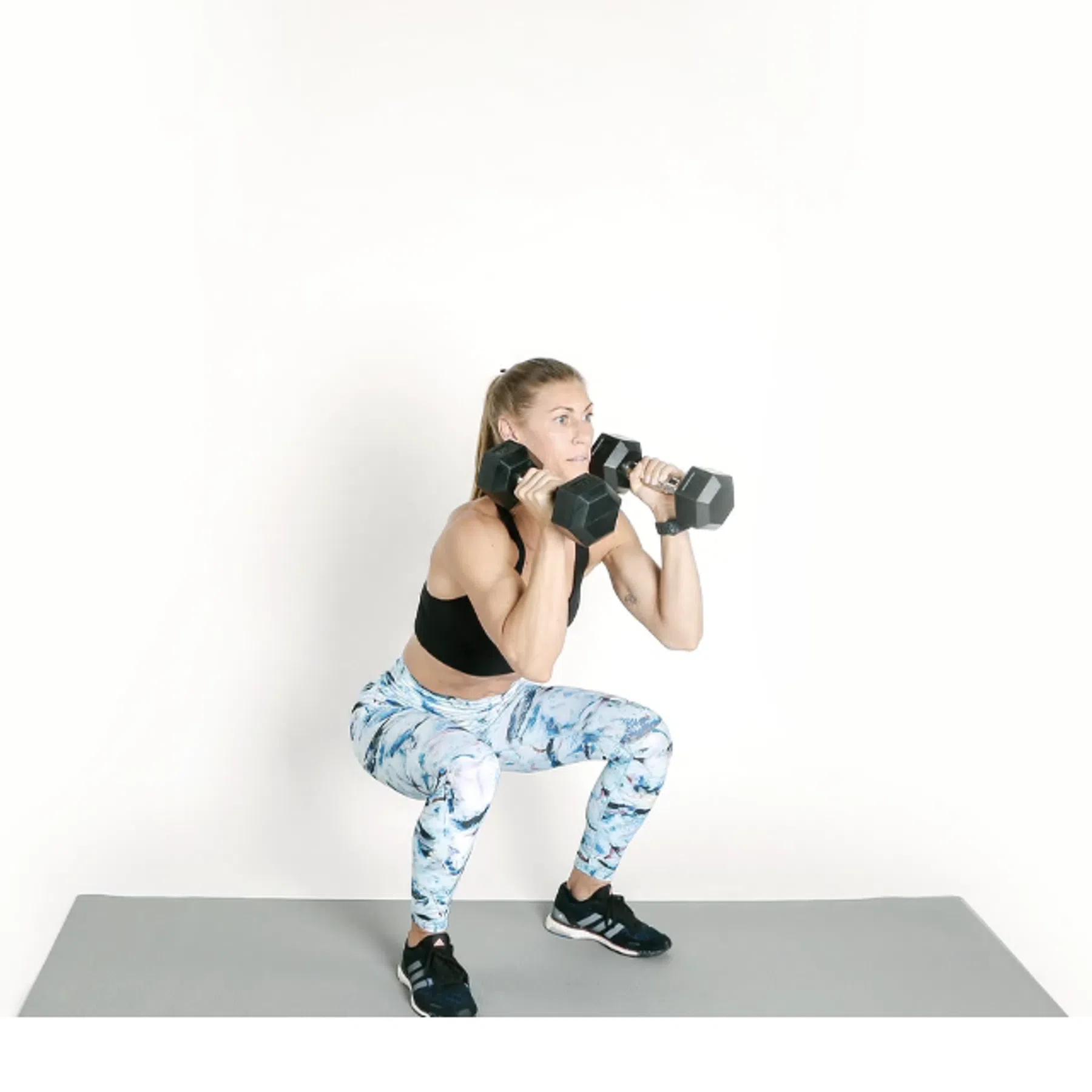 Vrouw doet Squat to Overhead Press